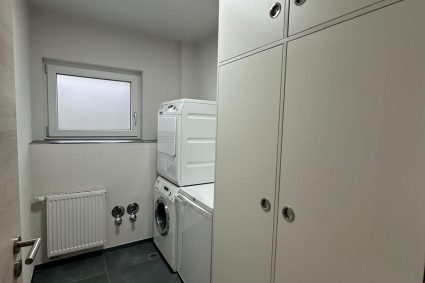 Hauswirtschaftsraum mit Waschmaschine und Trockner Hauswirtschaftsraum mit Waschmaschine und Trockner
